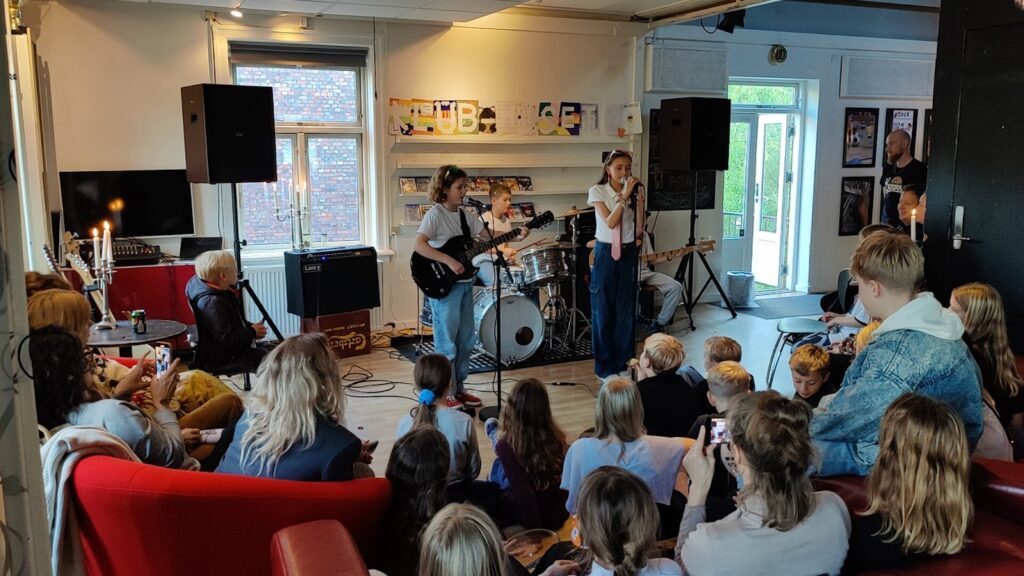børn spiller musik i klub foran andre børn
